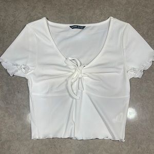 A plain white cropped shirt size 4. It has a little cut out in the front.